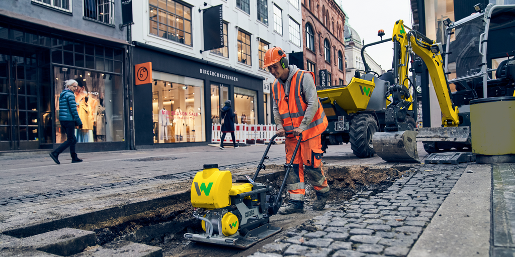 man working at an innercity constrcution site with a light weight vibratory plate